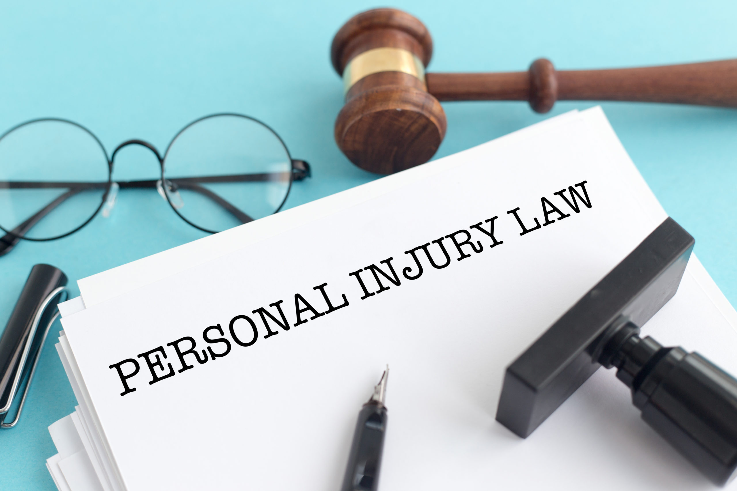 Document that says "personal injury law" and glasses, stamp, and pen